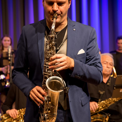 Bild vergrößern: Der musikalische Leiter Marco Vincenzi  während er Saxophon spielt