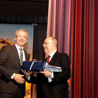 Bild vergrößern: Landrat Dr. Christoph Schnaudigel übergibt das Gastgeschenk an Herrn Schneider