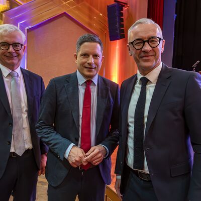 Bild vergr&ouml;&szlig;ern: Drei M&auml;nner stehen nebeneinander.