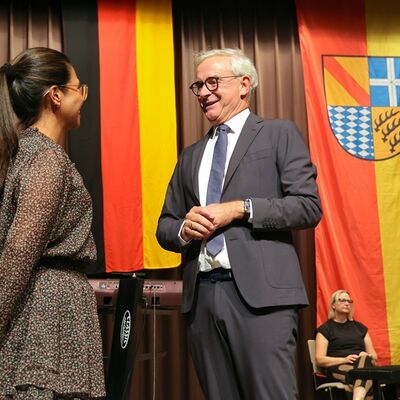 Bild vergr&ouml;&szlig;ern: Auf der B&uuml;hne nahm sich Landrat Dr. Christoph Schnaudigel Zeit f&uuml;r pers&ouml;nliche Gespr&auml;che und gratulierte den Eingeb&uuml;rgerten zu ihrem besonderen Tag.