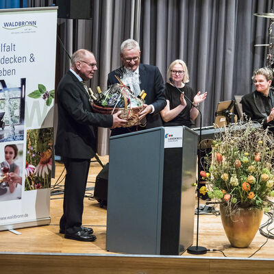 Bild vergrößern: Landrat Dr. Christoph Schnaudigel bedankt sich bei Eberhard Roth mit einem Präsentkorb für seine Festrede.
