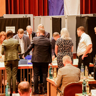 Bild vergrößern: Vertreterinnen und Vertreter der Kreistagsfraktionen zählen die Stimmzettel aus.
